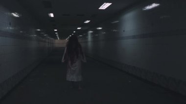 Korkunç zombiler hayalet yürüyüşü. Asyalı kadın makyajcı zombi, korkunç kadın korkunç korkunç kadın yüzü kanla kaplı terk edilmiş karanlık tonda kamerayı takip eden saçları var.