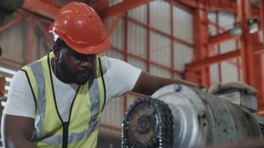 Endüstriyel fabrikada makinenin bakımını yapan bir güvenlik elbisesi giyen mühendis veya operatör, servis teknisyeni, metal levha fabrikasındaki fındık onarım makinesini sıkılaştırın.