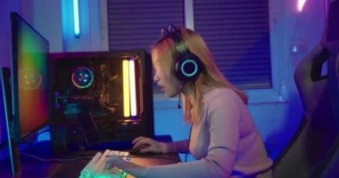 Oyun bitti. Çevrimiçi oyun oynayan Asyalı oyuncu kaybediyor ve üzgün, bilgisayar ekranında renkli LED ışıklar, oyun kulaklığı takan kadın, kaybettiği oyun için hayal kırıklığına uğruyor, E-Sport