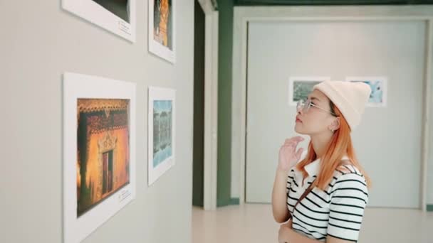 Жінка Стоїть Вона Дивиться Художню Галерею Перед Обрамленими Картинами Білій — стокове відео