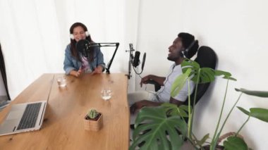 Çok ırklı insanlar, stüdyodaki mikrofon ve dizüstü bilgisayarla bir podcast kaydediyor.