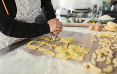 Kadın ellerini kapat ve taze ev yapımı ravioli makarnası hazırla.