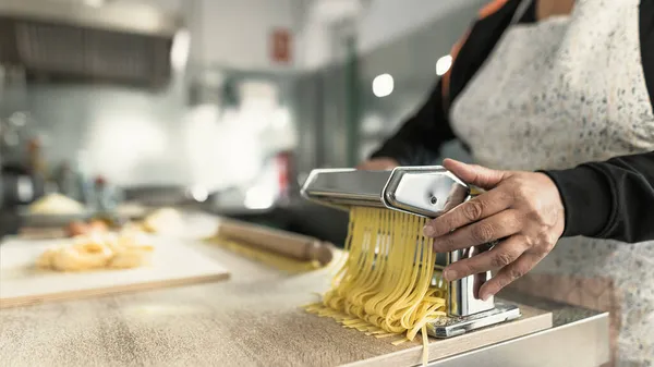 Tutup Tangan Perempuan Mempersiapkan Pasta Fettucine Segar Menggunakan Mesin Tradisional — Stok Foto