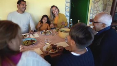 Mutlu Latin ailesi evde yemek yerken eğleniyor.
