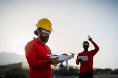 Drone engineer working with futuristic glasses on construction site - Aerial engineering concept clipart