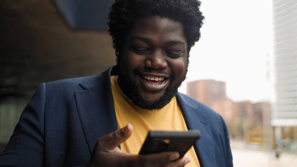 Happy Curvy African Man Using Mobile Smartphone Outdoor Stock Image