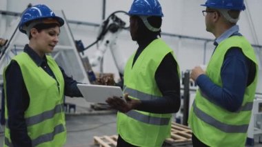 Robot fabrikasında çalışan mühendisler tablet-teknoloji endüstrisi konseptinde projeyi izlerken...