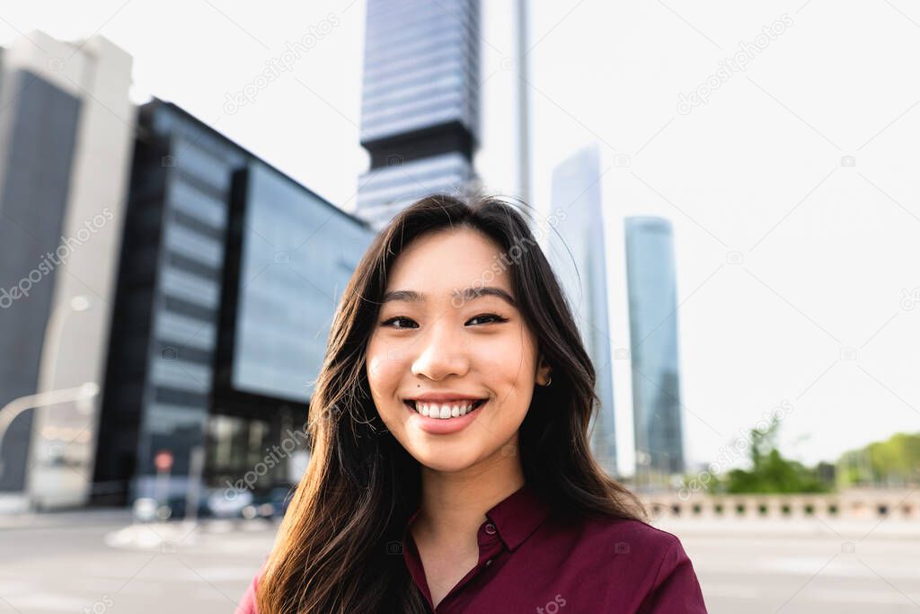 Happy Asian business woman outside enterprise office