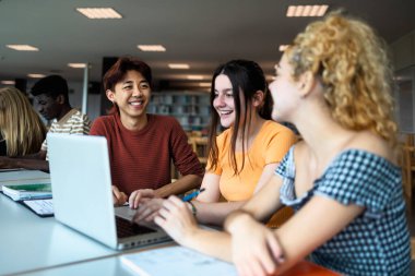 Üniversite kütüphanesinde birlikte okuyan çok ırklı gençler - Okul eğitimi kavramı