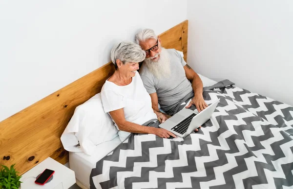 Casal Sênior Feliz Divertindo Usando Computador Enquanto Deitado Cama Abaixo — Fotografia de Stock