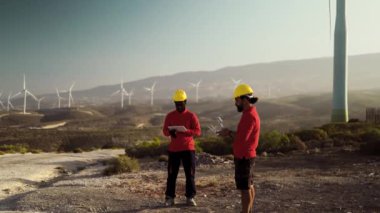 Rüzgar türbini çiftliğinde çalışan İHA mühendisleri - Alternatif enerji ve hava mühendisliği kavramı