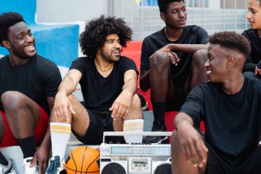 Genç çok ırklı insanlar müzik dinleyerek eğleniyorlar, klasik müzik kutusuyla, sokak insanlarının yaşam tarzıyla.