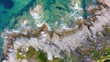 Okyanus dalgalarının hava manzarası, İtalya 'nın kuzeyindeki Santa Teresa Gallura' nın en güzel sahil noktalarından birini süsleyen kayalık kıyı şeridini vuruyor.