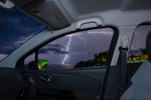 海の上に落雷の景色を望む車の窓から見ると — ストック写真