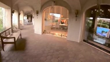 PORTO CERVO, İtalya - 3 Ağustos 2020 'de Porto Cervo, Sardinya, İtalya' daki lüks alışveriş caddelerinin kemerlerinin altında yapılan yürüyüşün hiperlapası. Tatil köyü Costa Smeralda 'nın ana merkezidir.