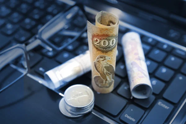 Rolled dirhams on top of keyboard Royalty Free Stock Photos