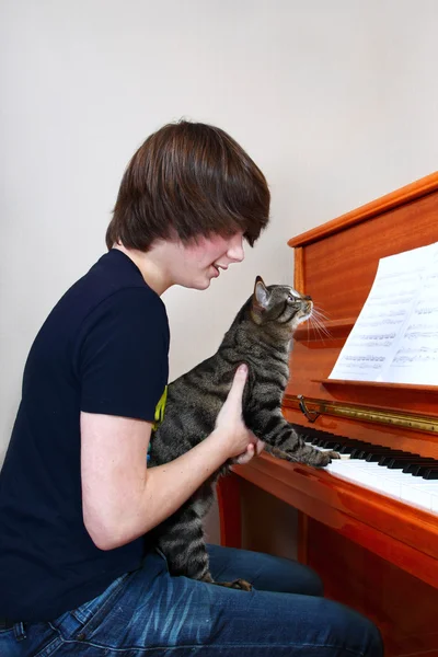 男孩和猫弹钢琴 — 图库照片