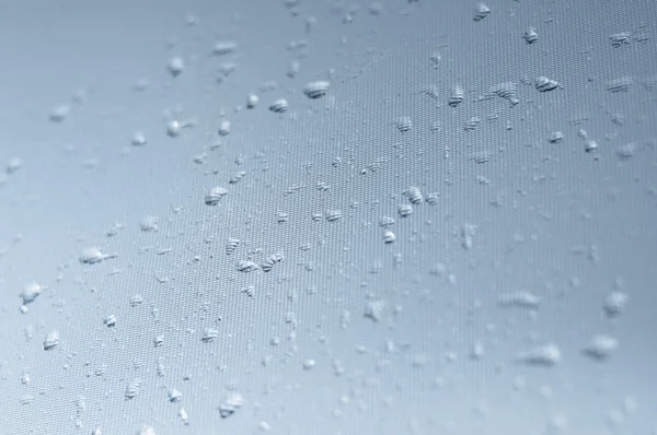 Water druppels op getextureerde glas — Stockfoto