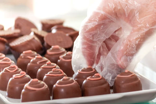 Verkoopster schikken chocolade truffels — Stockfoto