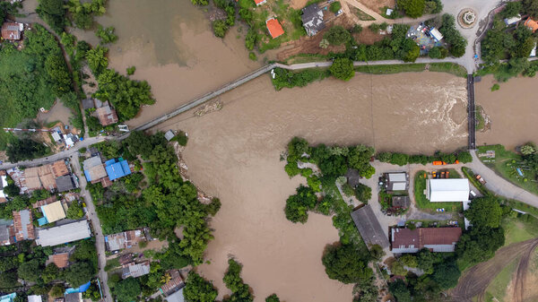 Tha Ruea, Ayutthaya, Thailand - October 2021: Aerial view of Rama 6 Dam (Phra Narai Gate) with powerful of water. During Flood disaster in Central of Thailand. Many buildings are submerged in water. Photo disaster from drone