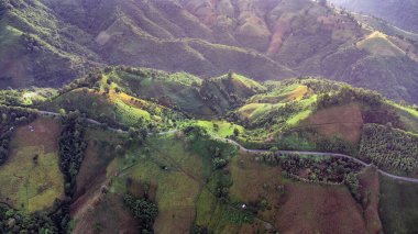 Sabah yağmur yağdıktan sonra dağların tepesindeki gökyüzü manzarası sisli ve yeşil orman, Doi sakad, Pua, Nan, Tayland. Güzel dağları aşarak yol üzerinden ulaşım. İHA 'dan ateşlenmiş..