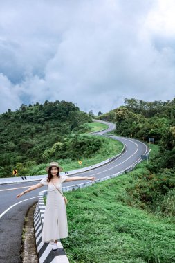 3 numaralı yolda geçmişi olan güzel bir bayan ya da yağmurdan sonra yeşil ormanlı dağların tepesinde bir gökyüzü yolu..