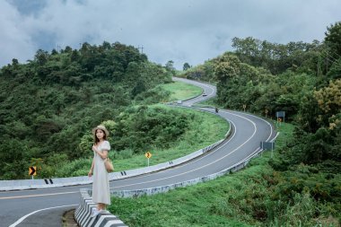 3 numaralı yolda geçmişi olan güzel bir bayan ya da yağmurdan sonra yeşil ormanlı dağların tepesinde bir gökyüzü yolu..