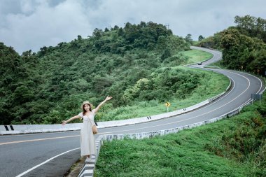 3 numaralı yolda geçmişi olan güzel bir bayan ya da yağmurdan sonra yeşil ormanlı dağların tepesinde bir gökyüzü yolu..