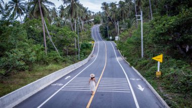 Nakorn Sri Thammarat Eyaleti, Tayland - Ekim 2021: Khao Phlai Barajı 'ndaki güzel Khanom Sichon Yolu üzerinde yürüyen tanımlanamayan kadın. Drone Aerial View tarafından çekilmiştir.