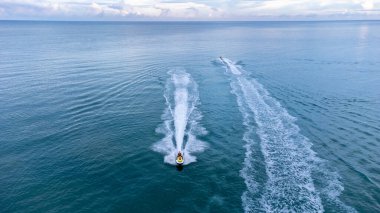 Gökkuşunun gözleri, açık deniz turkuazında yüksek hızda giden jet ski teknesinin görüntüsü.. 