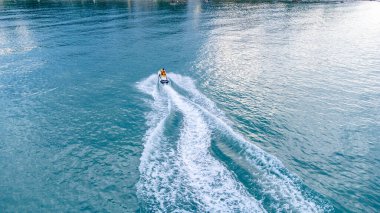 Gökkuşunun gözleri, açık deniz turkuazında yüksek hızda giden jet ski teknesinin görüntüsü.. 