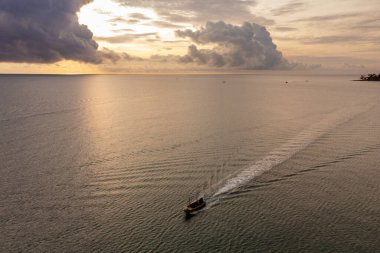 Gün batımını deniz ufkunda seyrederken gemiler denizde ilerlerken