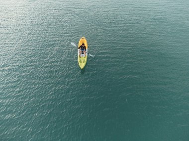 Aerial View 'dan deniz kayakçısı. Kafkas Sporcusu Sarı ve Mavi Kayıkçı Sahilde Sahilde Yüzüyor.