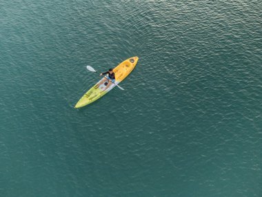 Aerial View 'dan deniz kayakçısı. Kafkas Sporcusu Sarı ve Mavi Kayıkçı Sahilde Sahilde Yüzüyor.
