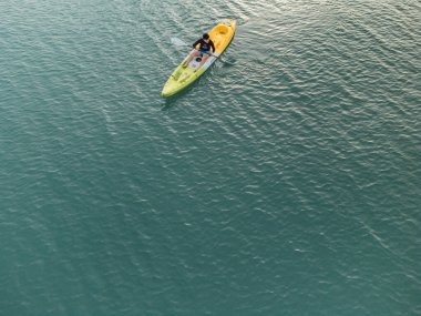 Aerial View 'dan deniz kayakçısı. Kafkas Sporcusu Sarı ve Mavi Kayıkçı Sahilde Sahilde Yüzüyor.