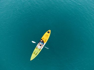 Aerial View 'dan deniz kayakçısı. Kafkas Sporcusu Sarı ve Mavi Kayıkçı Sahilde Sahilde Yüzüyor.