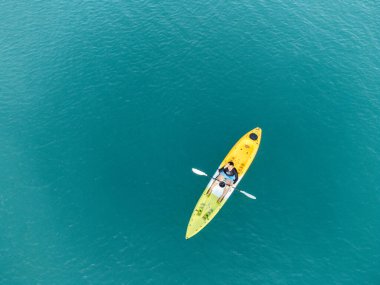 Aerial View 'dan deniz kayakçısı. Kafkas Sporcusu Sarı ve Mavi Kayıkçı Sahilde Sahilde Yüzüyor.