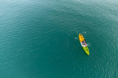 Aerial View 'dan deniz kayakçısı. Kafkas Sporcusu Sarı ve Mavi Kayıkçı Sahilde Sahilde Yüzüyor.