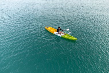 Aerial View 'dan deniz kayakçısı. Kafkas Sporcusu Sarı ve Mavi Kayıkçı Sahilde Sahilde Yüzüyor.
