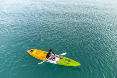 Aerial View 'dan deniz kayakçısı. Kafkas Sporcusu Sarı ve Mavi Kayıkçı Sahilde Sahilde Yüzüyor.