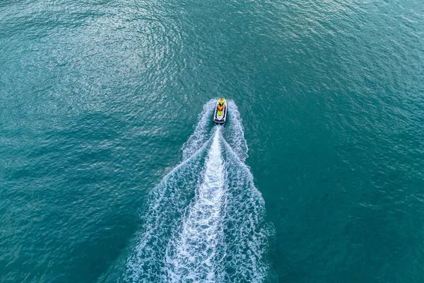 ターコイズブルーの澄んだ海を高速で巡航するジェットスキーボートの空中鳥目図 — ストック写真
