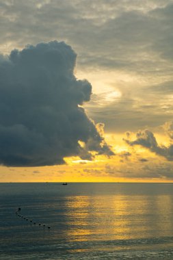 Denizde berrak bir gökyüzü vardı ve güneşin doğuşunun arka planında büyük bir bulut vardı.