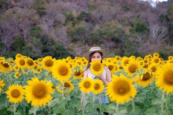 Ayçiçekli mutlu kız doğanın tadını çıkarıyor ve yaz ayçiçeği tarlasında gülümsüyor. Özgürlük kavramı ve...