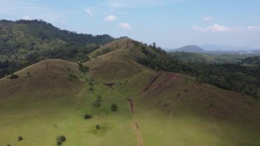 4K Kel Dağ ya da Phu Khao Ya üzerinde yeşil çimen ve mavi gökyüzü. Tayland 'ın Ranong eyaletindeki doğal seyahat cazibelerinden biri.
