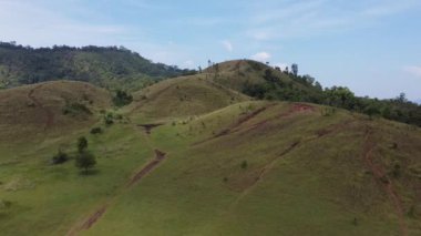 4K Kel Dağ ya da Phu Khao Ya üzerinde yeşil çimen ve mavi gökyüzü. Tayland 'ın Ranong eyaletindeki doğal seyahat cazibelerinden biri.