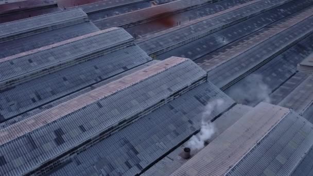 夕阳西下 工厂大楼的屋顶 在蓝天下冒着白烟 无人机从工厂顶部拍摄的空中照片 — 图库视频影像