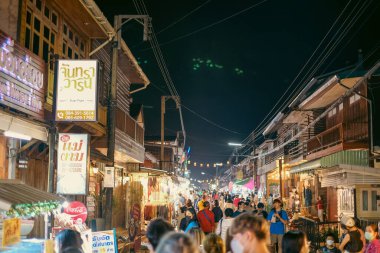 Chiang Khan, Loei Tayland - Aralık 2021: Geceleyin Chiang Khan 'da gezen ve alışveriş yapan turistler eski ahşap bina ve turist kalabalığıyla birlikte.