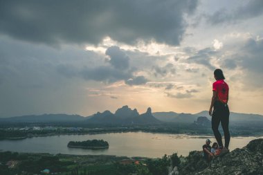 Dağ manzaralı maceraperest adam. Phu Sub Lek, Lopburi, Tayland 'ın gizli mücevheridir. Khao Jeen Lae' nin görülemeyen günbatımı gökyüzünü göl suyunun üzerinde görmek için..