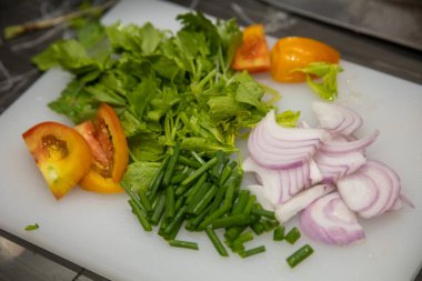 Vegetables for making Thai salad are located on the chopping board.