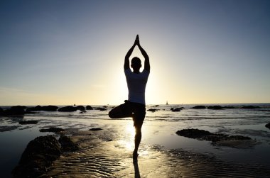 Asyalı adam yoga sahilde çalış.